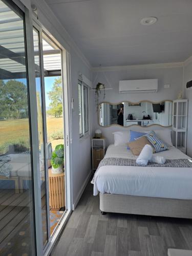 a bedroom with a large bed and a sliding glass door at Whispering Vines in Lovedale