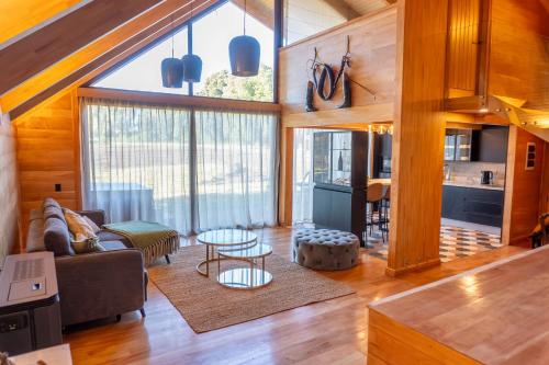 a living room with wooden walls and a large window at Hotel Gran Wolf - Haras Santa Amelia in Negrete