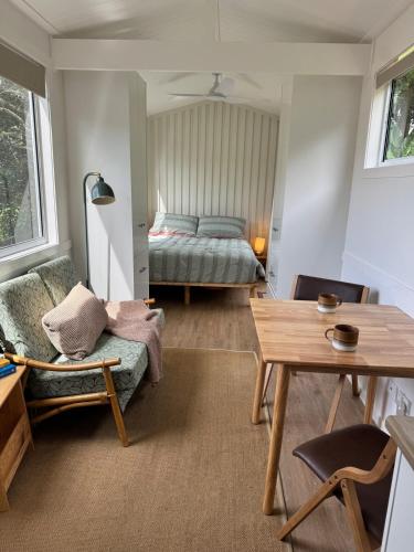 a living room with a bed and a table at Tiny Escape in Lennox Head
