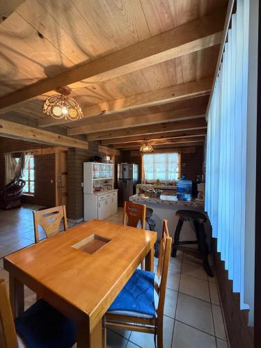 a kitchen and dining room with a wooden table and chairs at Cabaña Cuevas Tapalpa in Tapalpa