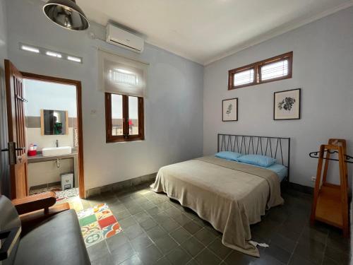 a bedroom with a bed and a sink at Sabi House Kates in Timuran