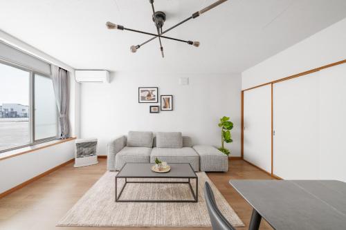 a living room with a couch and a table at Asahikawa Stay Ecole 101 in Asahikawa