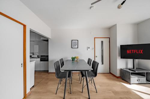 a dining room with a table and black chairs at Asahikawa Stay Ecole 101 in Asahikawa