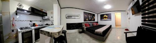a small room with a bed and a kitchen at Book & Sleep Cancun in Cancún