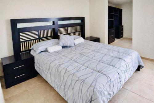 ein Schlafzimmer mit einem großen Bett mit hölzernem Kopfteil in der Unterkunft Casa Mi Chula in Veracruz