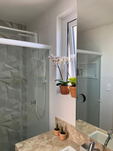 a bathroom with a shower and a sink and a mirror at Moderno & Prático Centro in Florianópolis
