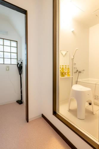 a room with a mirror and a white bench in a room at あわら湯のまち駅から徒歩3分の湯の花ハウス in Awara