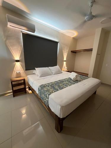 a bedroom with a large bed and a tv on the wall at Hotel Urban Tacana in Tapachula
