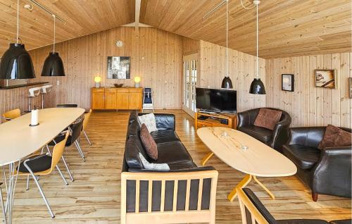 a living room with a couch and tables and chairs at Holiday Home Ankersholm Rødby Ii in Rødby