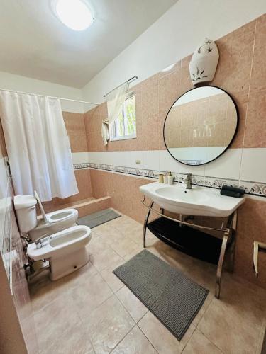a bathroom with a sink and a toilet and a mirror at Villa del Sol #1 in La Laguna