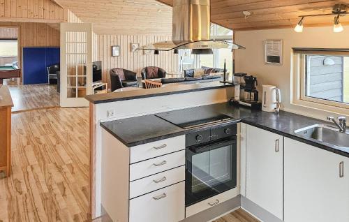 a kitchen with a sink and a stove top oven at Holiday Home Ankersholm Rødby Ii in Rødby