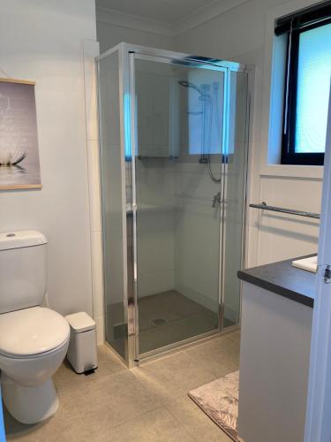 a bathroom with a toilet and a glass shower at George Town Central Apartment in George Town