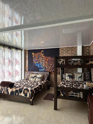a bedroom with two bunk beds and a mural of a tiger at Casa Africa in Calima