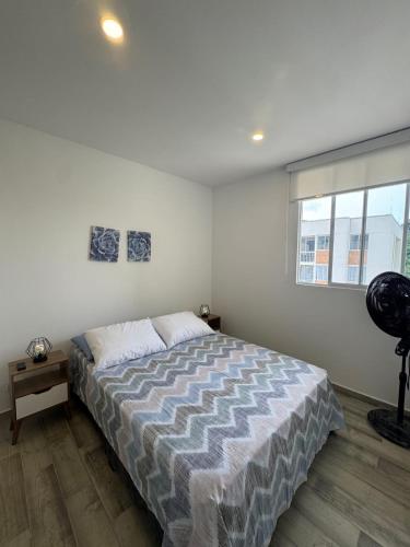 a bedroom with a bed and a window at Oasis Villeta Apartamento in Villeta