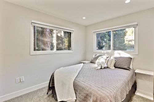 a bedroom with a bed and two windows at Slopeside Chalet on River Next To WP Resort I Fantastic Views I Private Hot Tub I Gas Firepit I Game Room I Activity Program in Winter Park