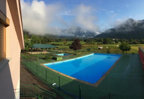 une grande piscine avec des montagnes en arrière-plan dans l'établissement Pinarillos, à Sarvisé
