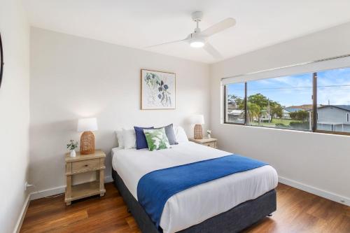a bedroom with a bed and a large window at Sunset Reset in Soldiers Point