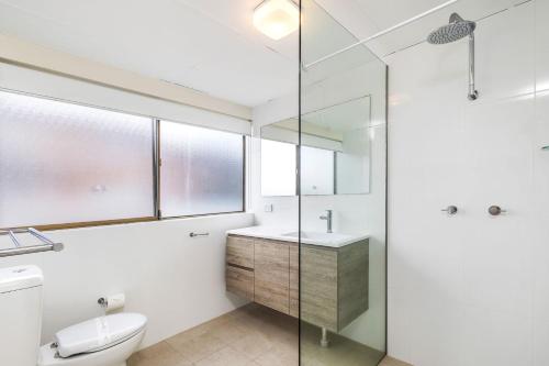 a bathroom with a toilet and a sink and a shower at Sunset Reset in Soldiers Point