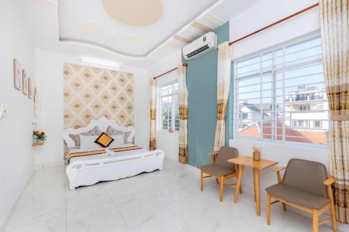 a bedroom with a bed and two chairs and a table at Homestay 30 Võ Thị Sáu in Vung Tau