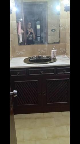 a woman taking a picture of a bathroom sink at Casa Quarto 3 in Jaraguá do Sul