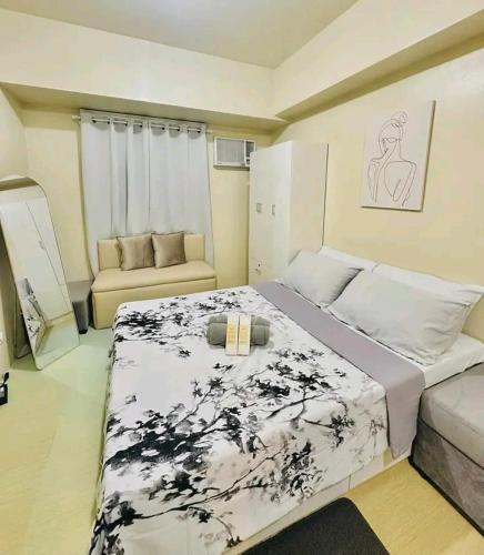 a bedroom with a large bed and a couch at Ilo2stayAirbnb 1BR 334 in Molo