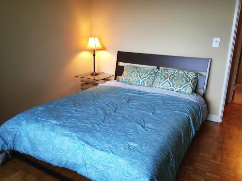 a bedroom with a bed with a blue bedspread and a lamp at Downtown 1 Bedroom Apartment 18H in Atlanta