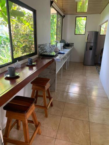 a kitchen with a long counter with stools in it at Hospedaje las rocas in Puerto Jiménez