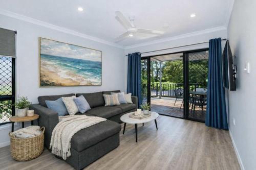 a living room with a couch and a view of the ocean at Golfside Haven 2 Bedroom Duplex with Golf Course in Rosslea