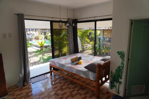 a bedroom with a bed and a large window at La Provinzia Exclusive Use - 3 Air-Conditioned Rooms 3 Fan Cooled Huts Good for 12 People in Camotes Islands