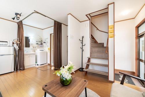 a living room with a vase of flowers on a table at - 旅time 粉浜照 - 玉出駅まで徒歩3分 住吉大社まで徒歩13分 最大6人宿泊可能 in Osaka