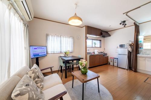 a living room with a couch and a table at - 旅time 粉浜照 - 玉出駅まで徒歩3分 住吉大社まで徒歩13分 最大6人宿泊可能 in Osaka