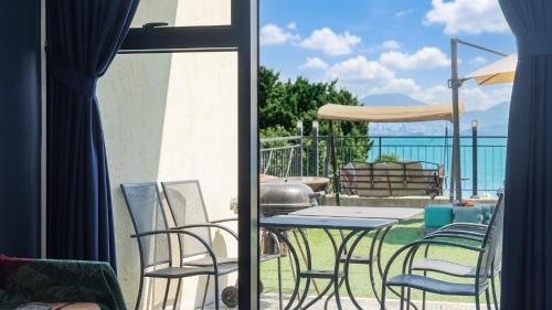 a patio with a table and chairs on a balcony at Yeosu Bokja Spa Pension in Yeosu