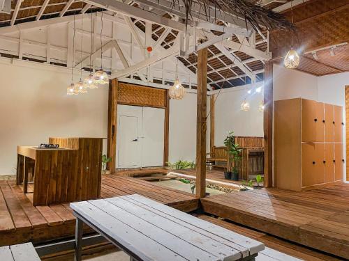 a large room with a wooden floor and a table at Bisita Hostel in Siquijor
