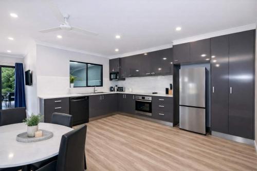 a kitchen with a table and a kitchen with black cabinets at Golfside Haven 2 Bedroom Duplex with Golf Course in Rosslea
