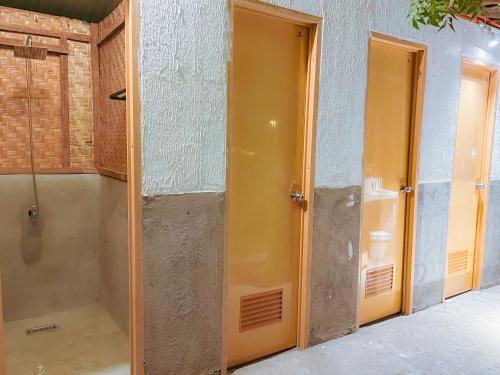 a bathroom with a shower and two doors in a room at Bisita Hostel in Siquijor