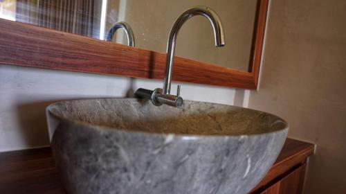 a sink with a faucet in a bathroom at Saluvi Hill's in Pulau Sarang
