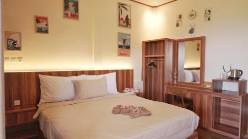 a bedroom with a bed with a teddy bear on it at Saluvi Hill's in Pulau Sarang