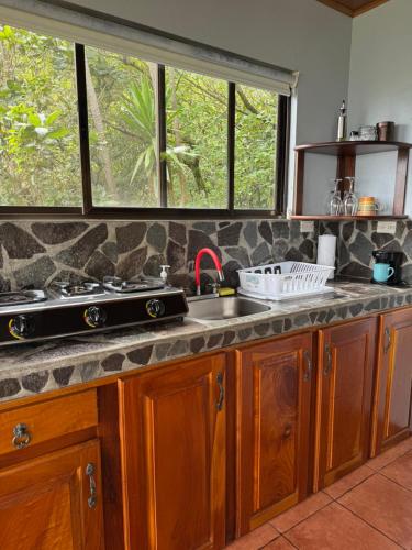a kitchen counter with a sink and a window at Rainbow Valley Lodge Costa Rica in Monteverde Costa Rica