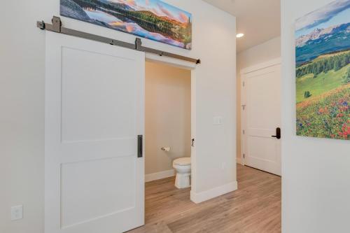a bathroom with a toilet and a painting on the wall at Downtown WP Loft 14 I Huge Hot Tub I Great Views I Additional Bunk Area I Activity Program in Winter Park