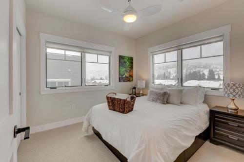 a bedroom with a bed and two windows at Downtown WP Loft 14 I Huge Hot Tub I Great Views I Additional Bunk Area I Activity Program in Winter Park