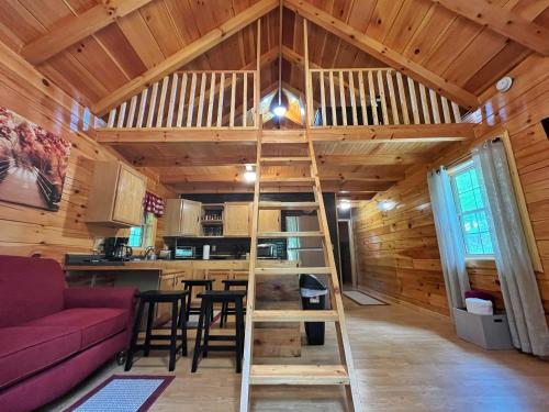 a room with a loft bed in a log cabin at Pluggy's Place - Perfect Location - Outdoor Fire pit in Beattyville