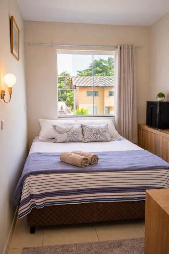 a bedroom with a large bed with a window at Quarto tranquilo e confortável dentro de residência particular, 3 km do Aeroporto , 1,5 km da Praia in Navegantes