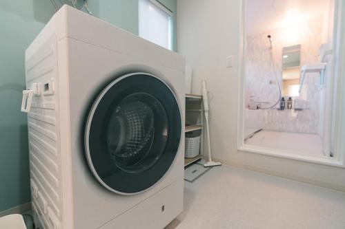 a washing machine in a bathroom with a shower at Grandeur Biei in Biei