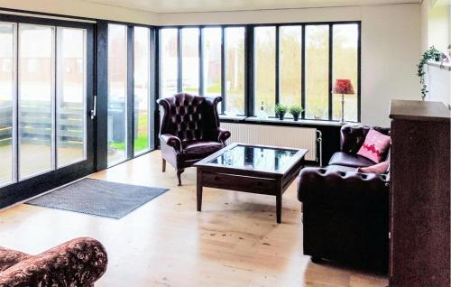 a living room with two chairs and a coffee table at 1 Bedroom Nice Home In Hurup Thy in Ullerup