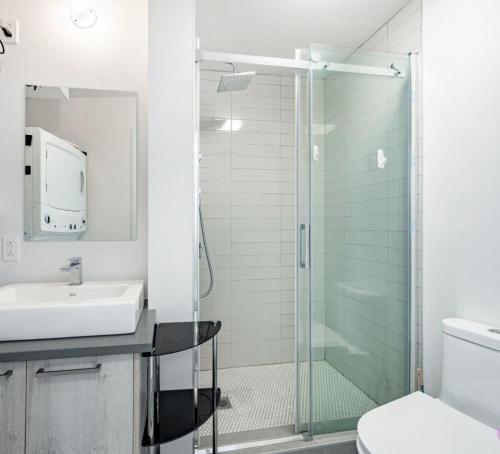 a bathroom with a glass shower and a sink at Cozy stays in Montreal
