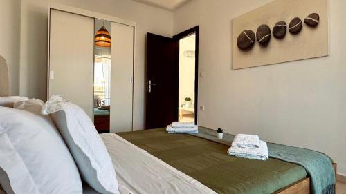 a bedroom with a bed with towels on it at 7th Heaven Luxury Villa in Kallithea Halkidikis