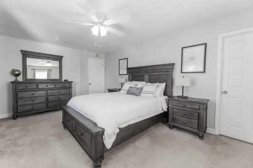 a bedroom with a bed and two dressers and a ceiling fan at Cozy Nashville Retreat 10 Min to Broadway in Nashville