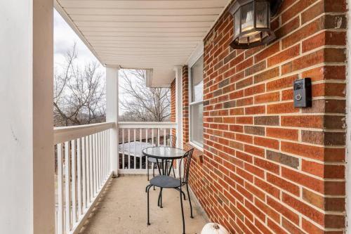 a table and chairs on a balcony with a brick wall at Cozy Nashville Retreat 10 Min to Broadway in Nashville