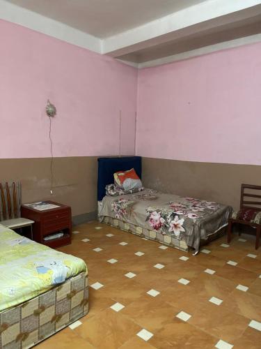 two beds in a room with pink walls at Beit Gedi in Cairo