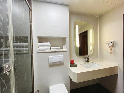 a bathroom with a toilet and a sink and a shower at Ibis Yixing Longbeishan Forest Park in Yixing